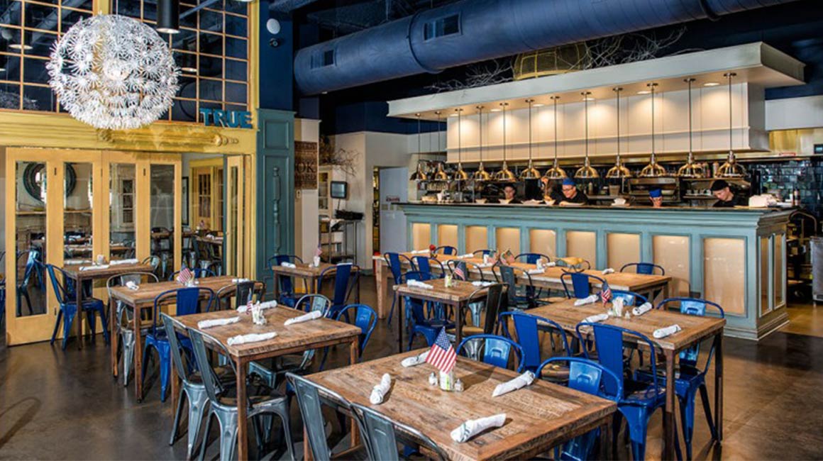 wooden tables and blue metal chairs in restaurant